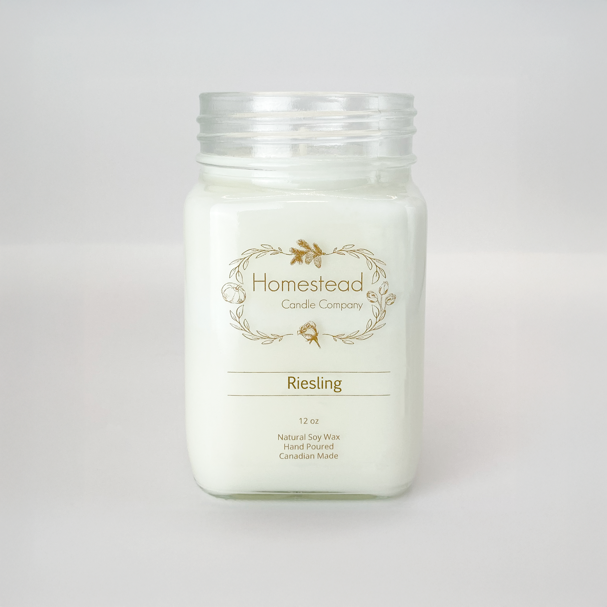 Clear glass jar of Homestead Riesling soy candle with white wax and a wine-inspired pear fragrance.