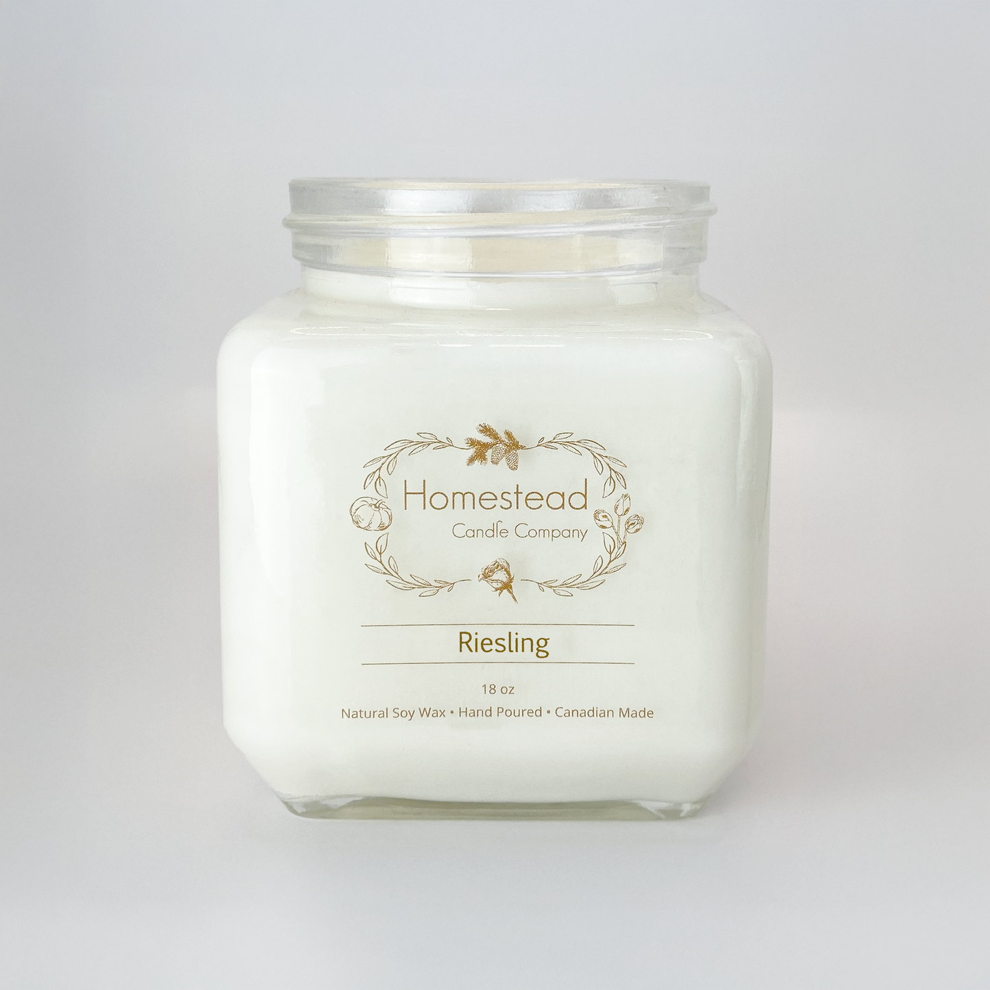 Clear glass jar of Homestead Riesling soy candle with white wax and a wine-inspired pear fragrance.