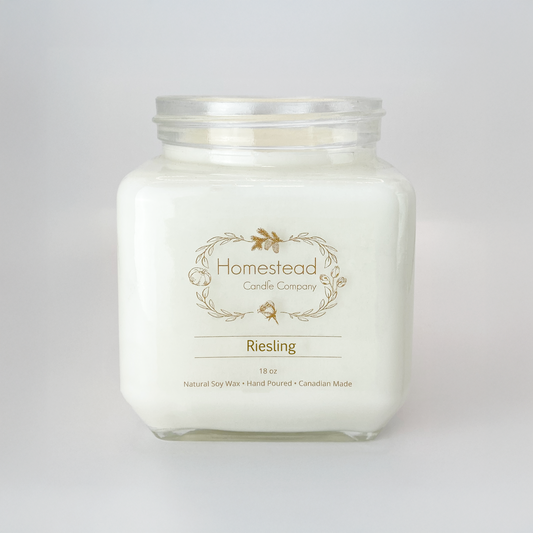 Clear glass jar of Homestead Riesling soy candle with white wax and a wine-inspired pear fragrance.